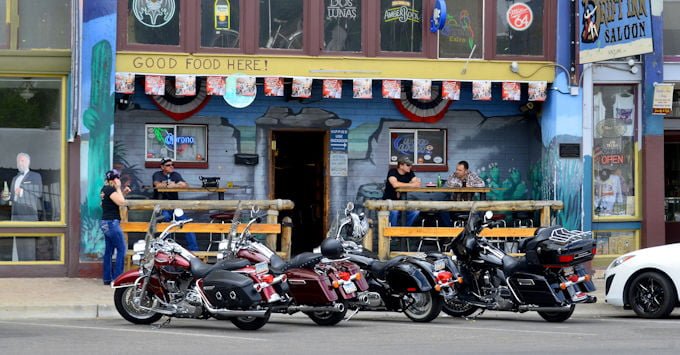 Row of Harley Davidson motorcycles parked in front of a bar